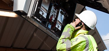 Technicus kijkt naar de binnenkant van een informatie bord