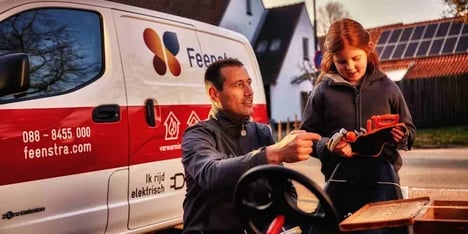 A man and a girl in front of a company car of Feenstra