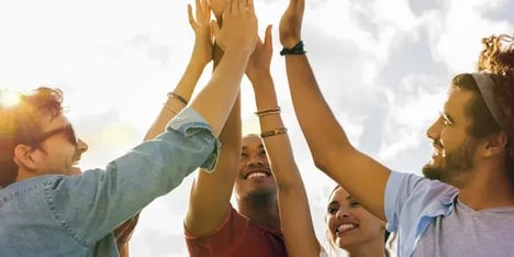 A group of men and a women showing their hands in the air for a high five