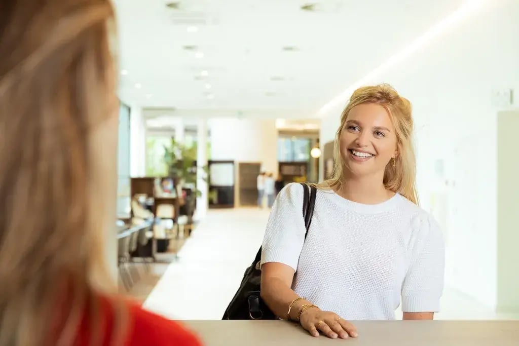 Twee dames in gesprek aan een balie