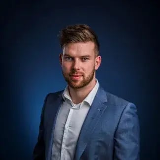 Man in blauw pak kijkt in camera