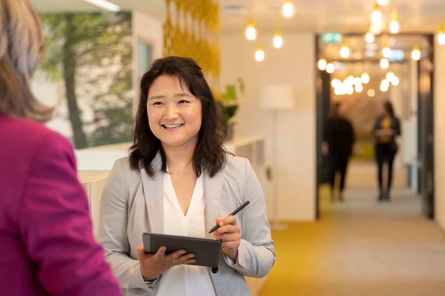 Vrouwelijke collega met tablet in haar hand.