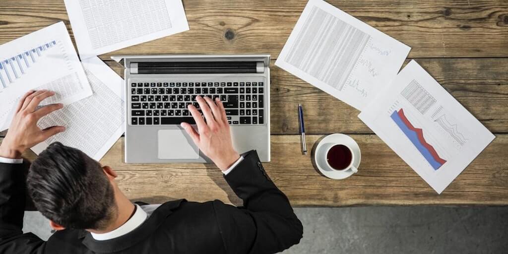 Top view person sitting at table with laptop and coffee