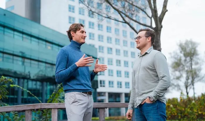 Twee mannen die in gesprek zijn bij een bedrijfsgebouw