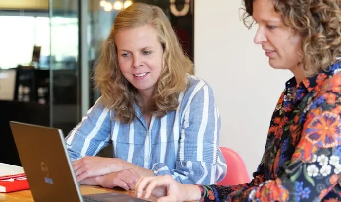 Collega's achter een laptop.