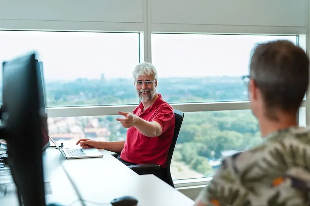 Meneer in rode shirt lacht met meneer in groen shirt