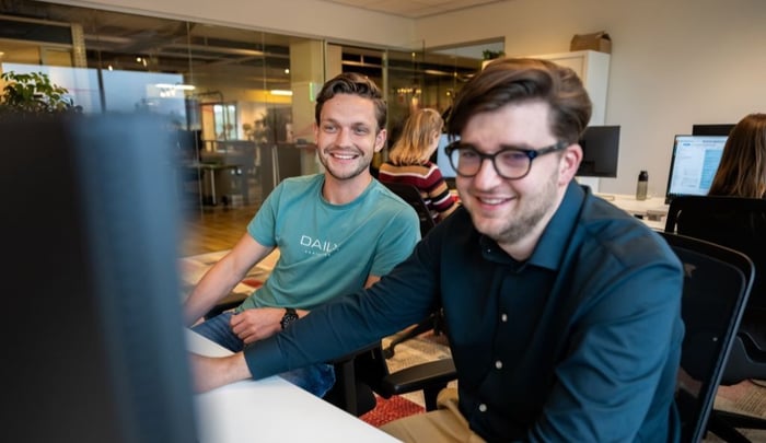 medewerkers lachend achter computerscherm