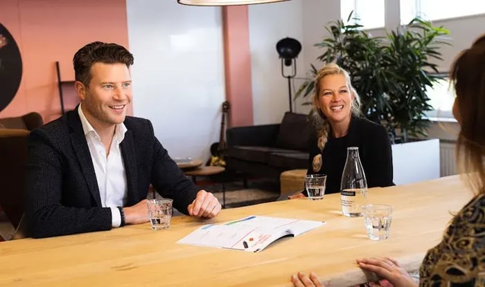 Man en twee vrouwen aan tafel in gesprek