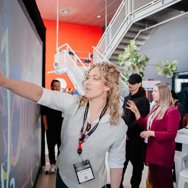 Vrouw met blonde krullen met een Conclusion cord om haar nek