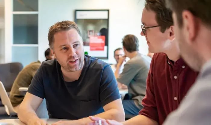 Twee mannelijke collega's in overleg.