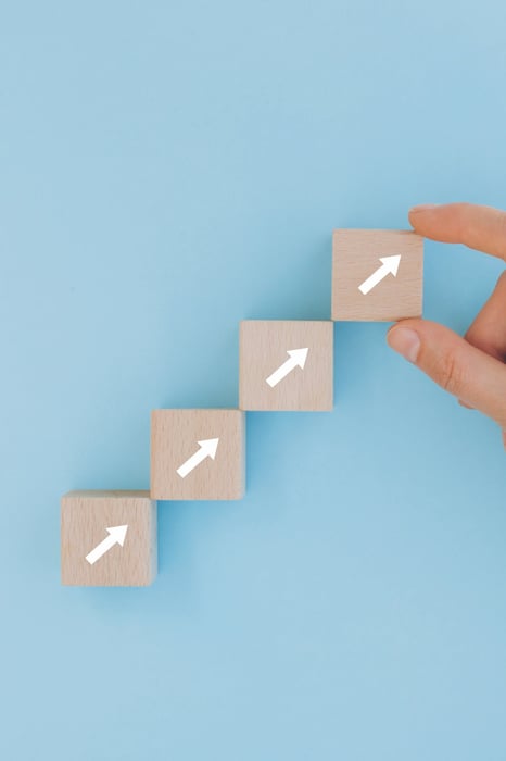 Hand dat blokken met pijlen achter elkaar neerlegt.