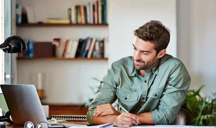 Een man maakt lachend notities