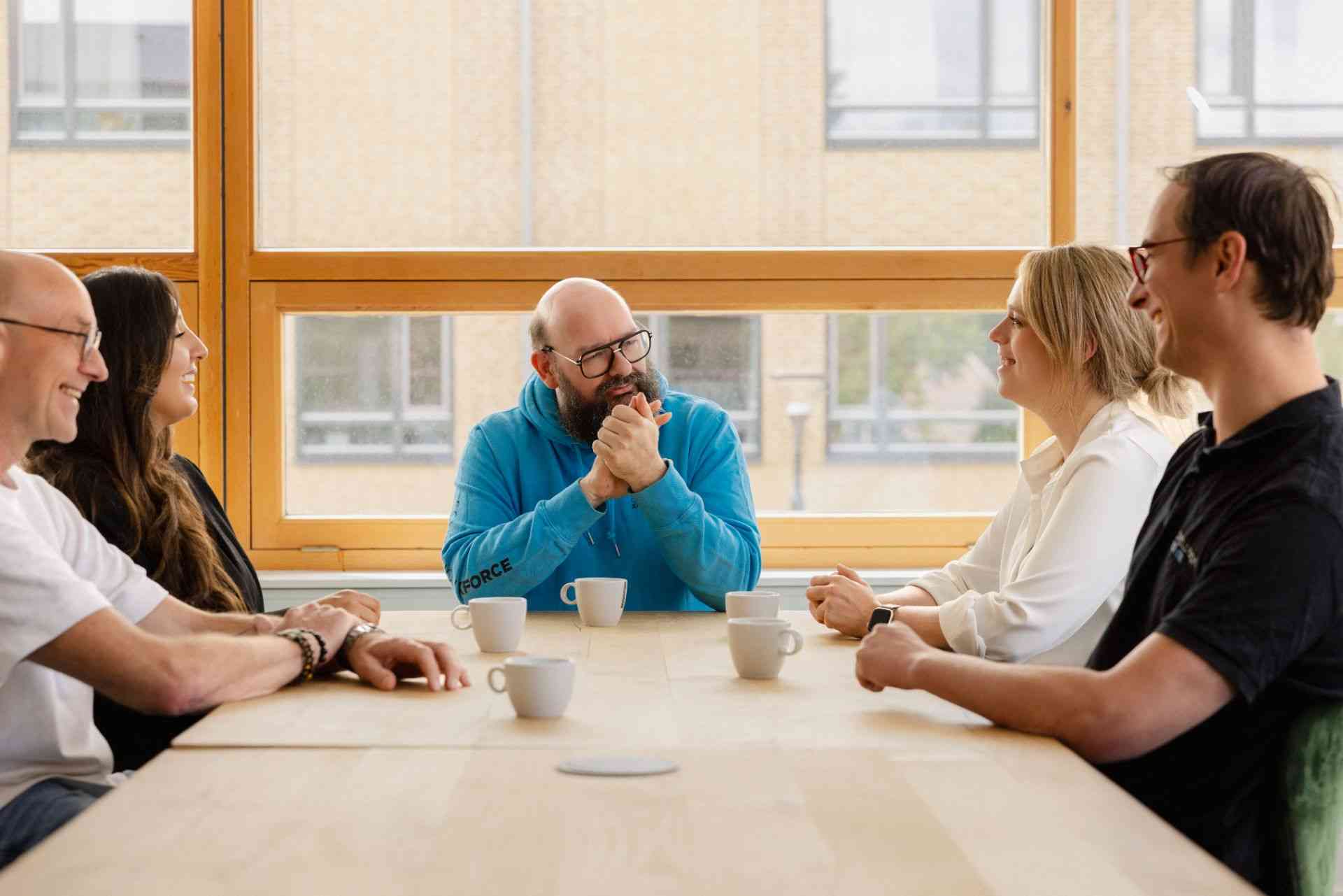 A group of people are sitting at a table and talking to each other.