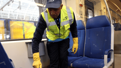 Een man die de trein schoonmaakt