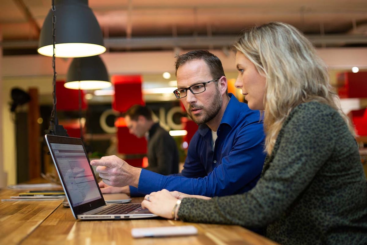 Een man en een vrouw achter een laptop