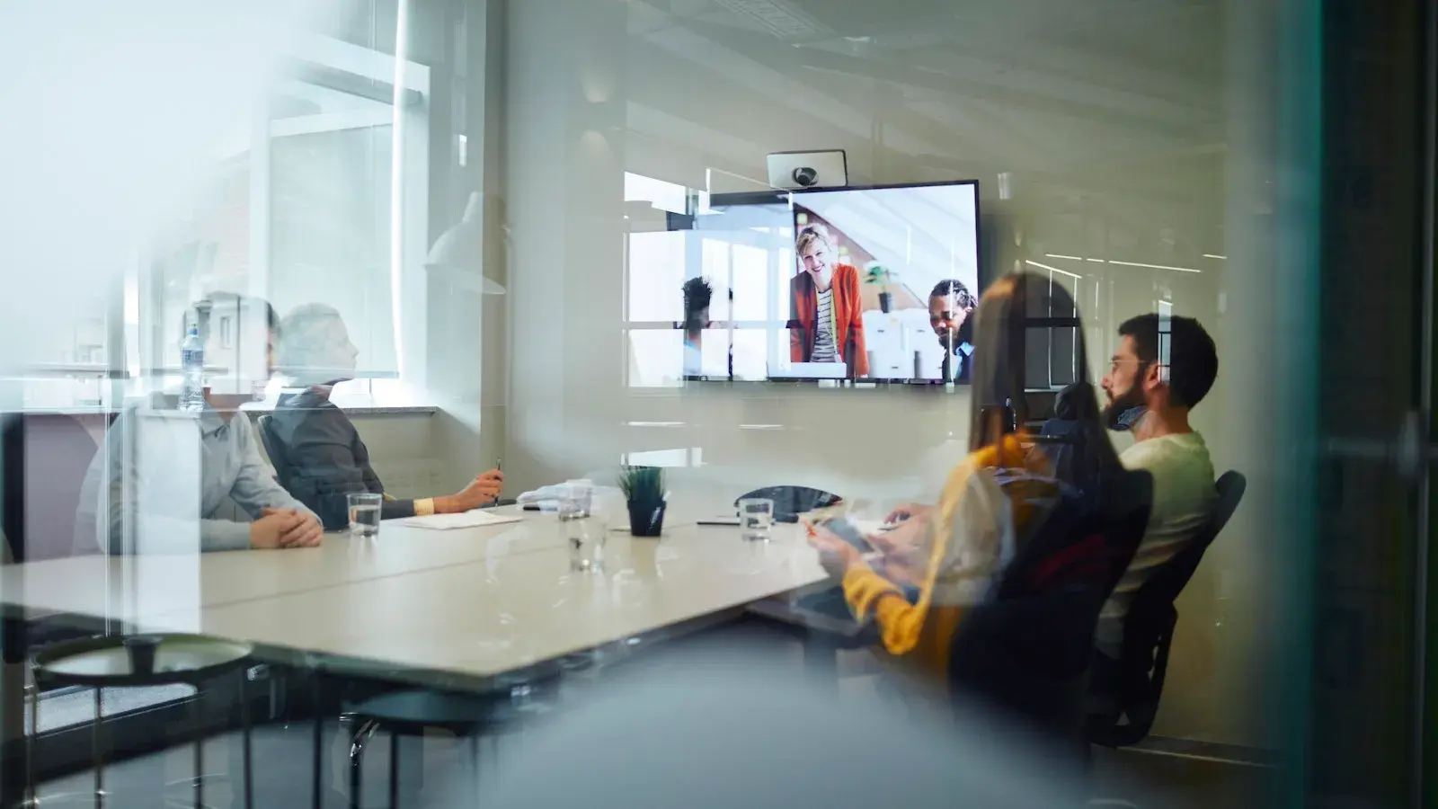 Team van collega's die in een online meeting aan tafel zitten