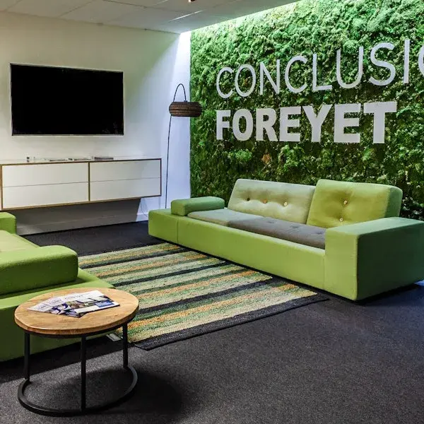 Ruimte met groene bank voor een wand met het logo van Conclusion ForeyeT
