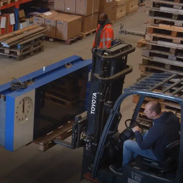 Collega's op de werkplaats met een heftruk