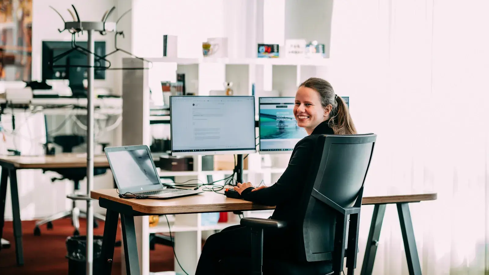 Een lachende vrouw achter haar bureau