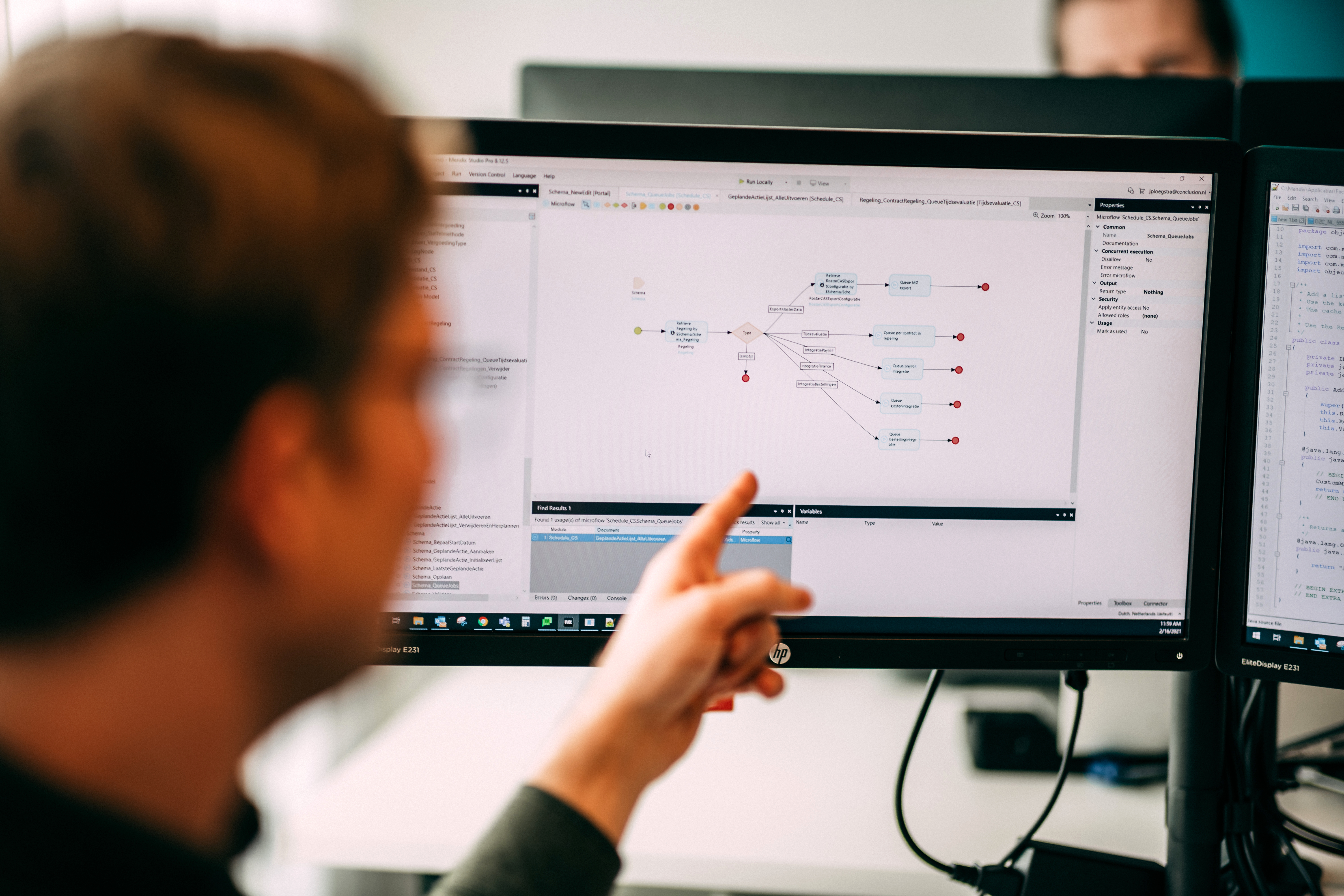 persoon wijst naar een Mendix-applicatie op computerscherm