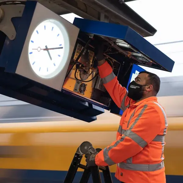 Man werkt aan informatie bord op station