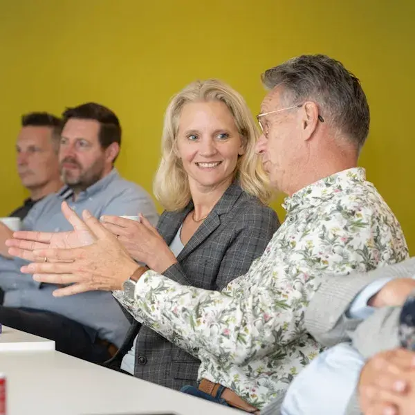 Collega's aan een tafel hebben een gesprek.