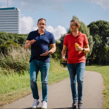 Twee collega's wandelen in de zon.