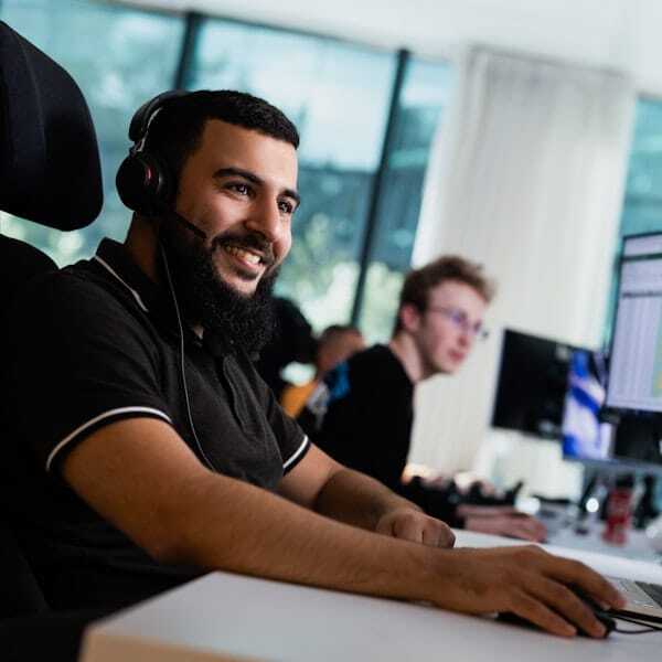 Mannelijke collega met headset kijkt vriendelijk.