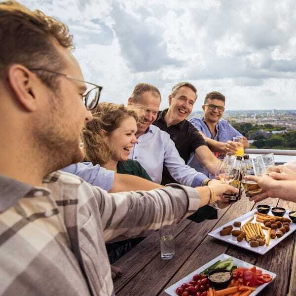 Collega's proosten aan tafel met eten.
