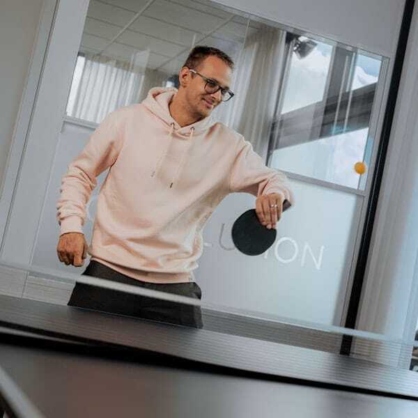 Mannelijke collega speelt tafeltennis.