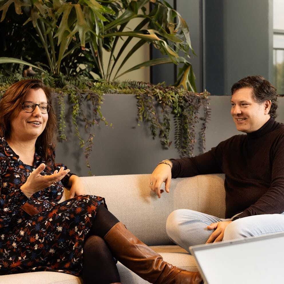 Collega's zitten op een bank.