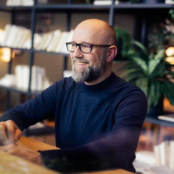 Mannelijke collega kijkt en lacht.