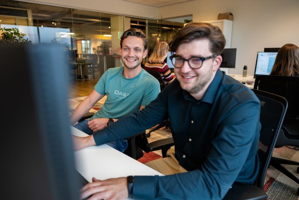 Twee collega's die naar het scherm kijken