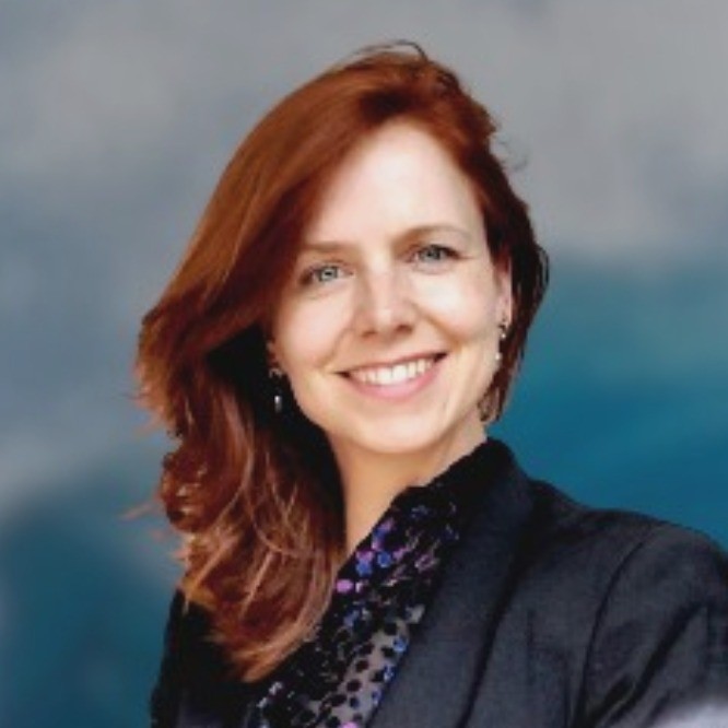 Ludwine Dekker die glimlacht, in een zwart blazer en een paarse blouse, met een vervaagde achtergrond