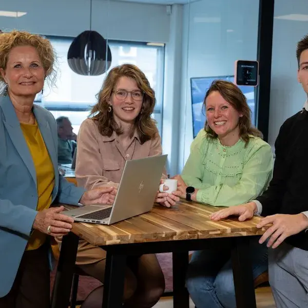 Personen aan een tafel met een laptop