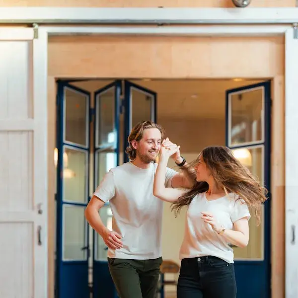 Man en vrouw lachend bij deuropening