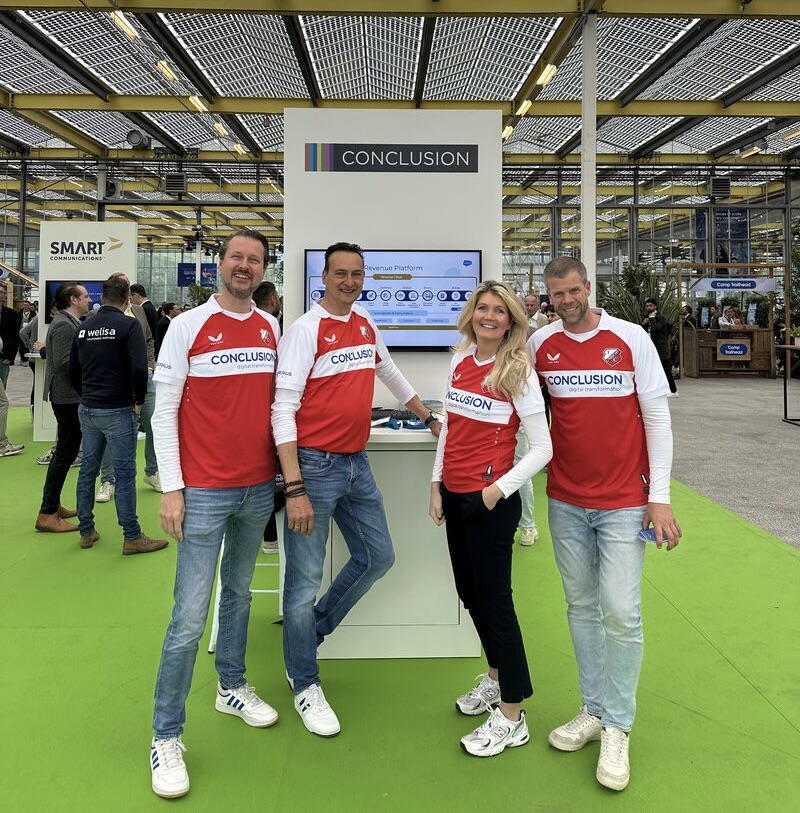 Vier collega's op een event in Conclusion shirts.