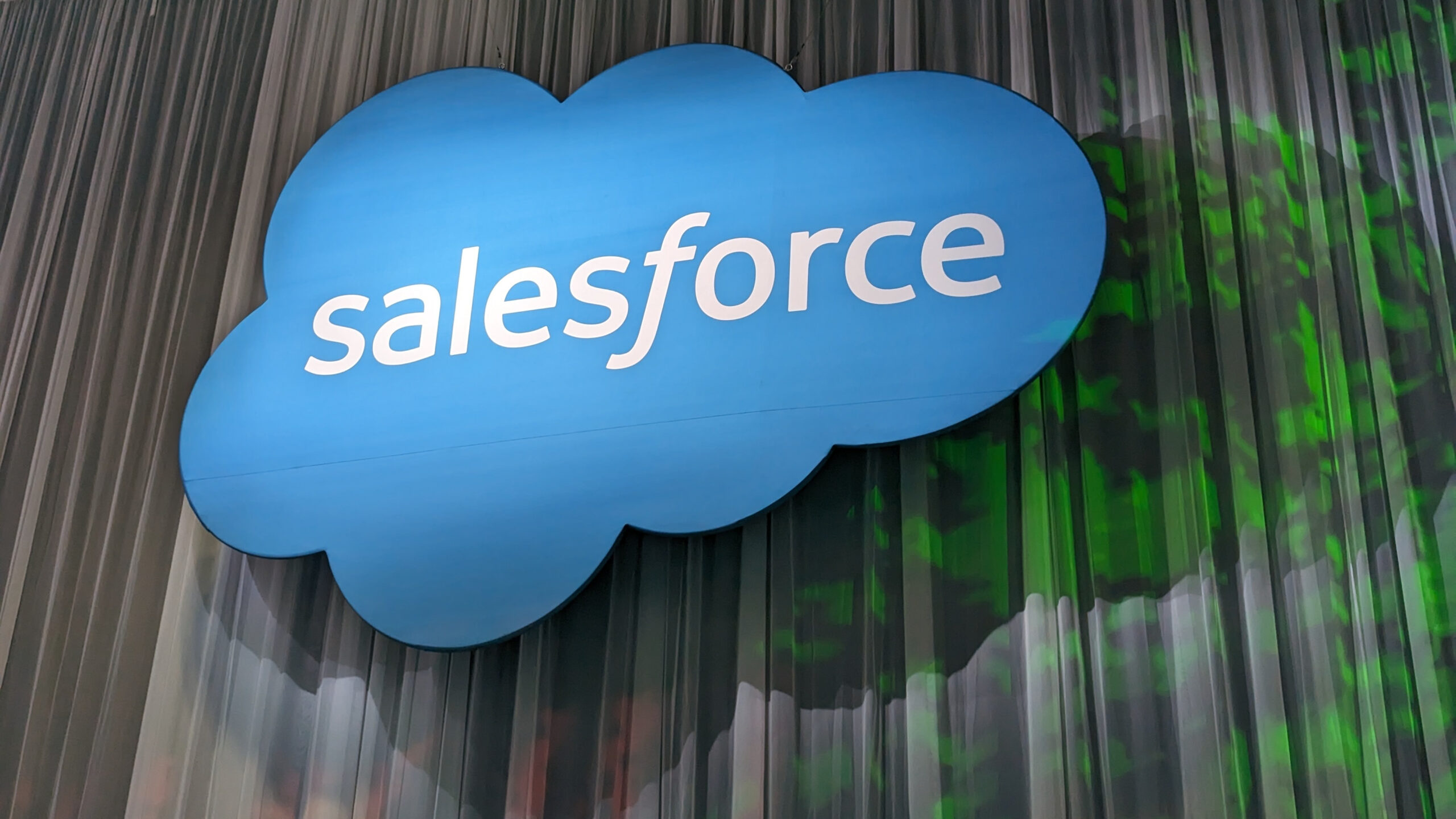 Het Salesforce-logo als verlicht bord op een decoratieve achtergrond.